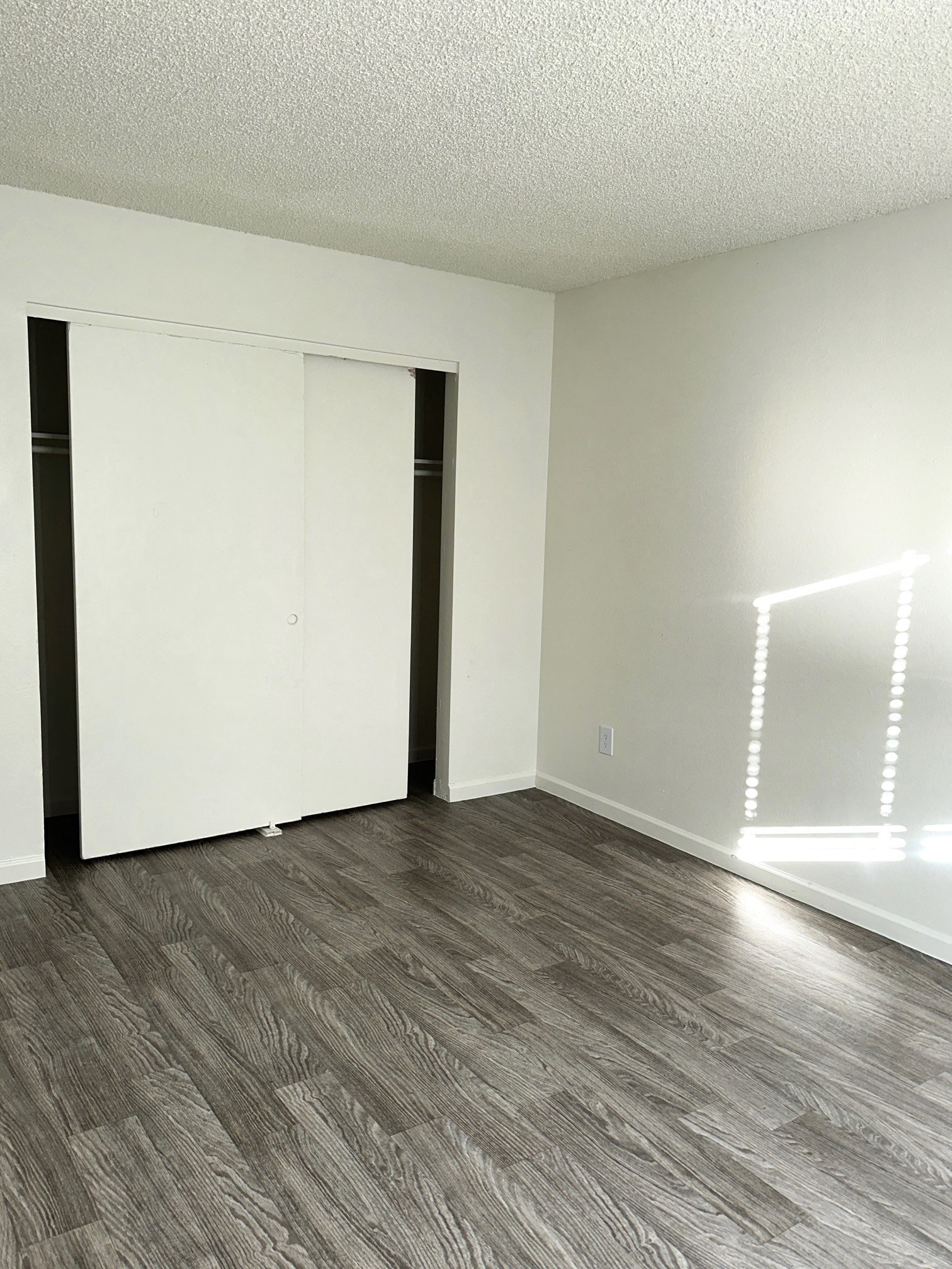 an empty living room with white walls and wood flooring